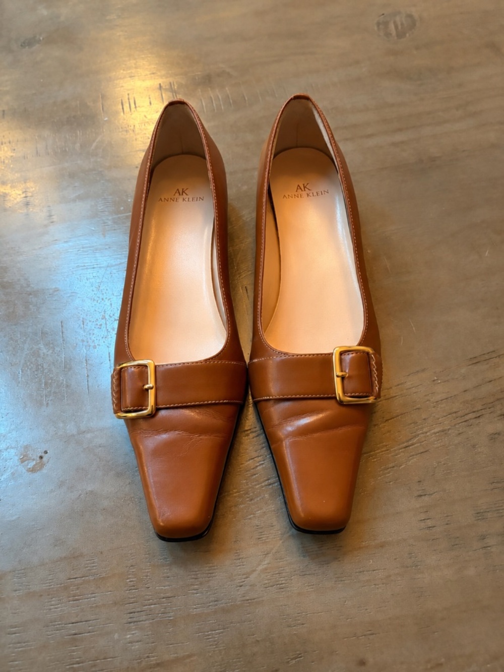Ann Klein caramel brown leather pumps with gold buckle.
